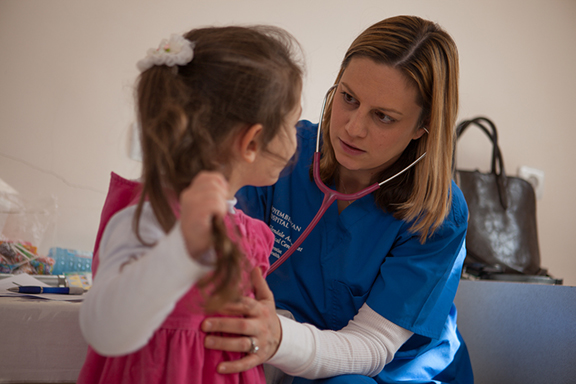 Pediatrician Dr. Karineh Aboulian examines a young girl from a nearby town in Noyemberian