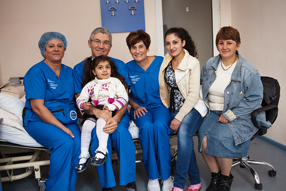 Oral and maxillofacial surgeon Dr. Armond Kotikian with a cleft palate patient prior to surgery, joined by Juliet Khodadadi, Rebecca Berberian and family members