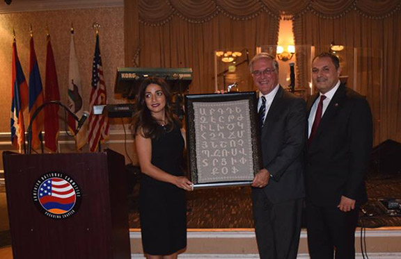 ANCA Pasadena Chairperson Vahe Majarian and Banquet organizing committee member Garin Kevoian presenting Pasadena Mayor Terry Tornek with a very special hand-woven embroidery of the Armenian Alphabet.
