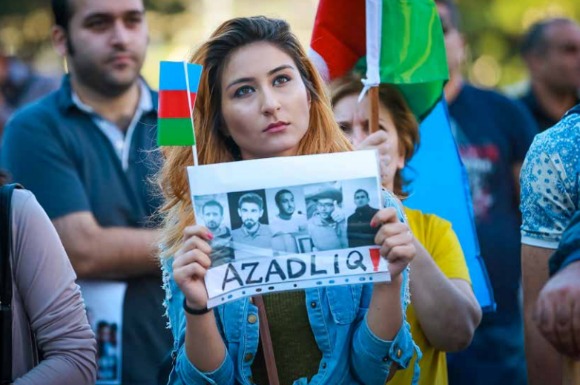 A protestor holds a sign calling for the release of unjustly imprisoned youth activists in Baku (Photo: Azadliq Radiosu/RFERL)