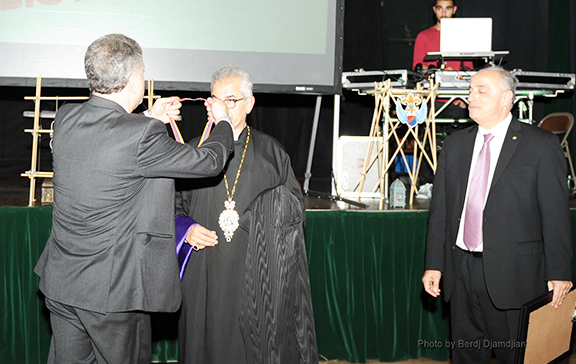 Western Prelate Archbishop Moushegh Mardirossian being awarded the "Extraordinary Medal" by Homenetmen Central Executive member Viggen Davtian