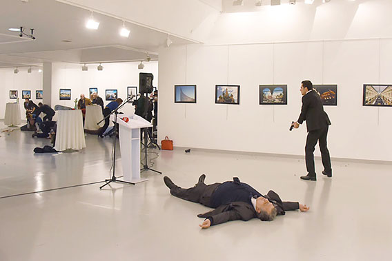 The man on the right, identified as the shooter, stands over the body of Ambassador Andrey Karlov (Getty Images)